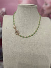 Elegant green chalcedony necklace with faceted stones and cubic zirconia charm on a beige display bust