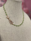 Elegant green chalcedony necklace with faceted stones and cubic zirconia charm on beige display bust